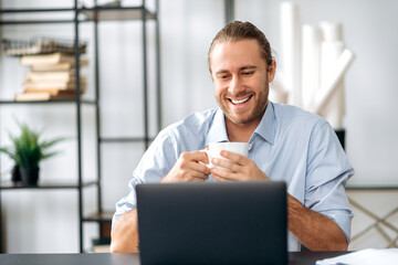 Happy confident caucasian guy, employee or freelancer, took a break from work, holds a cup of...