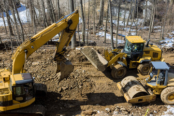 Under construction of a new asphalt road. The excavators, graders and road rollers working on the new road construction © ungvar