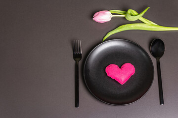 Festive creative black table setting with tulips on dark background
