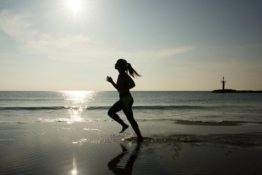 Sportswoman running along beach
