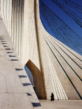 A woman walks through the arch of Tehran's Azadi Tower