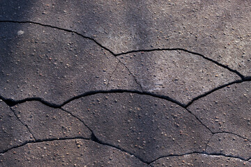 Obraz premium cracked asphalt texture with day light in the city - background