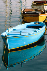Fototapeta na wymiar Colorful boats with magnificent blue tourquoise yellow and reflections on the water