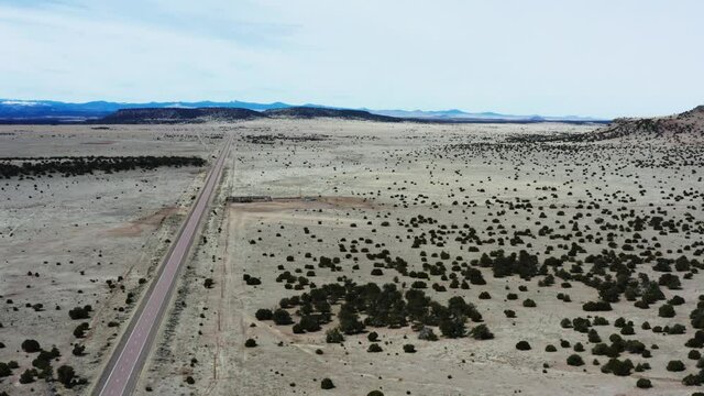 Majestic desert highway with single car in aerial drone view