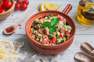 Delicious quinoa salad with avocado, cucumber and tomatoes on a rustic wooden table. Superfoods concept. Selective focus. View from above.