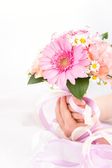 Obraz na płótnie Canvas ピンクの花束を持つ子供の手　花のプレゼントイメージ素材