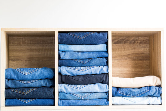 stack of jeans wooden box on a white background full of colored jeans 