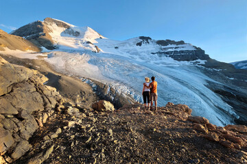 Adventurous couple hiking in mountains with view of  Athabaska glacier.  Mount Athabaska. Columbia Icefields. Alberta. Canada  - obrazy, fototapety, plakaty