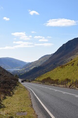 Fototapeta premium a steep and dangerous road near Cadair Idris with mountains either side and tal-y-llyn lake in the background