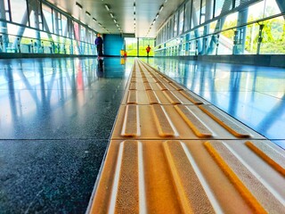 Picture of yellow tactile paving for blind handicap on tiles pathway.
