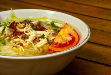Close up of Soto Ayam, an Indonesian traditional chicken soup on wooden table
