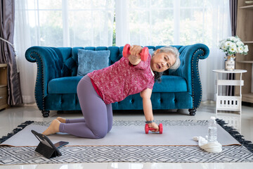 Portrait healthy senior woman exercise one arm dumbbell row