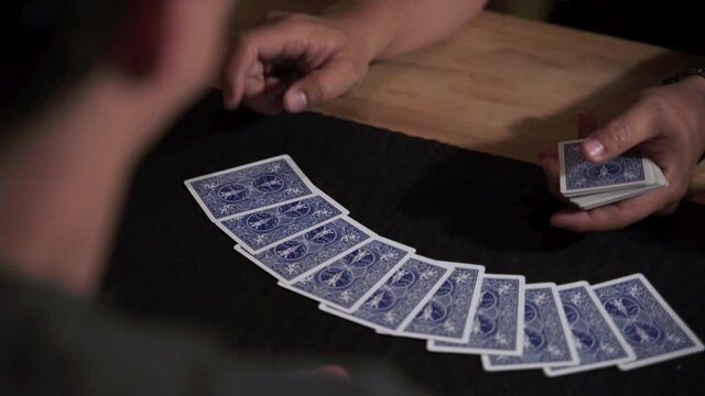 Cropped Image Of Men Playing Blue Poker Cards In A Wooden Table. - High Angle Shot, Selective Focus Shot