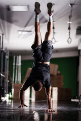 Fototapeta premium Muscular athlete standing and walking on hands upside down
