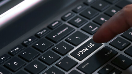 User finger press laptop keyboard button with JOIN US word. Concept for business and marketing....