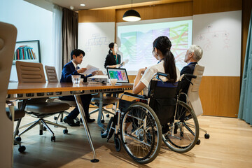 車椅子に乗った女性が会議に参加している