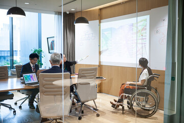 車椅子に乗った女性社員が指揮を執るプロジェクト会議