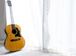 Obraz premium 窓際に立てかけたメンテナンス中のアコースティックギター。