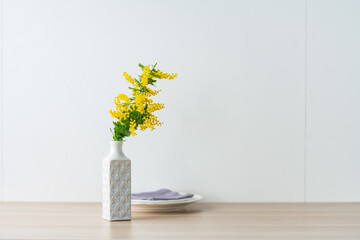 Bouquet of yellow mimosa flowers in a vase.
