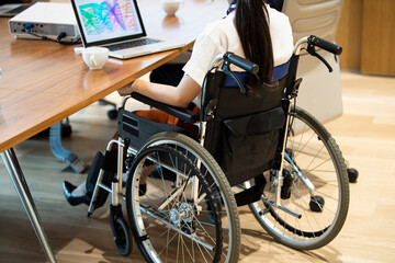 車椅子の女性社員が会議に参加している