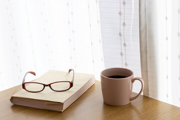 読書の休憩イメージ。本、コーヒー、眼鏡