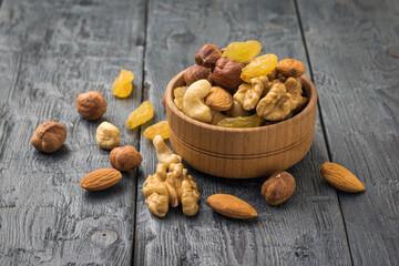 Fruit and nut mixture in a wooden bowl on a wooden table.