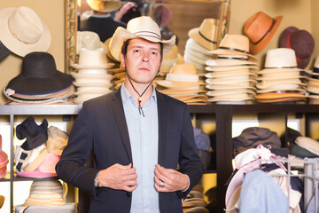 happy adult male try on western hat at the shopping center