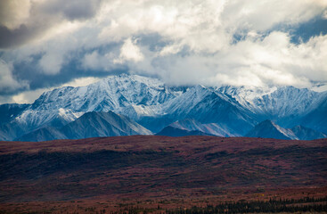 dramatic snow capped Alaskan mountain range inside the Denali National Park in Alaska taken during autumn.