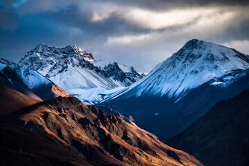 dramatic snow capped Alaskan mountain range inside the Denali National Park in Alaska taken during autumn.