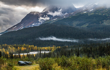 dramatic autumn landscape photo of mountain peaks and calm lakes in the Kenai Peninsula in Alaska .