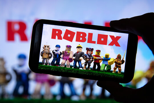 LONDON, UK - March 2021: Person Holding A Smartphone With Roblox Game Logo