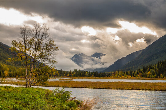 dramatic autumn landscape photo of mountain peaks and calm lakes in the Kenai Peninsula in Alaska .