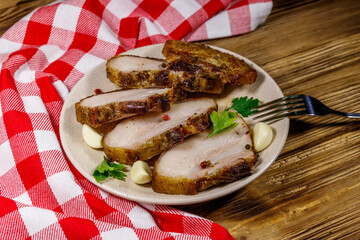 Baked pork belly in a plate on wooden table