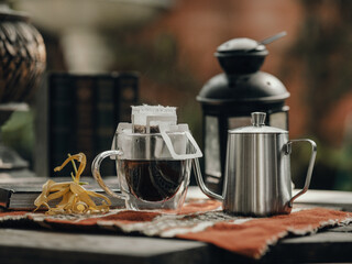 Brown earth tone color of dripped caffee with pot,books and lantern.Dripped Coffee prepared by allow boiled water to percolate through ground coffee.Relax and authentic style with favourite coffee cup
