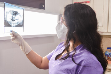 A female doctor checking a radiography x-ray.
Una odontóloga revisando una radiografía.