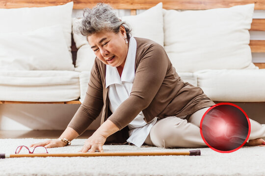 Asian senior woman falling down lying on floor at home alone. Elderly woman pain and hurt from osteoporosis sickness or heart attack. Old adult life insurance with hearlth care and treatment concept