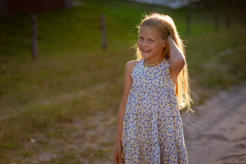 blonde girl runs on the sand at sunset, selective focus