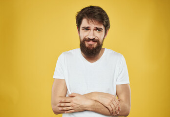 The man has his arms crossed over his chest against a yellow background cropped view