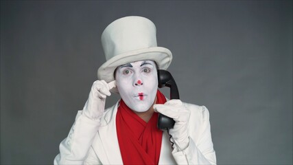 Mime calls by phone. Mime with an old pipe. boy-mime with the phone. Human emotions. Clown talking...