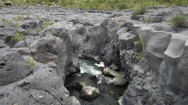 volcanic rock of Sicily nature split by a fault and smoothed by the waters flowing in a gorge of Simeto river 