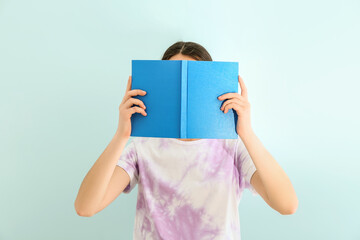 Woman with open book against color background
