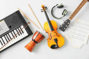 Different musical instruments and music notes on light background