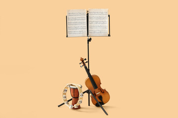 Note stand with music sheets and different musical instruments on color background