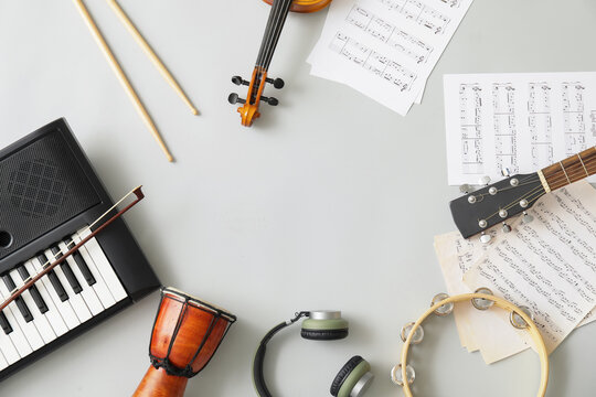 Frame made of different musical instruments and music notes on light background