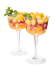 Glass bowls with tropical fruit salad on white background
