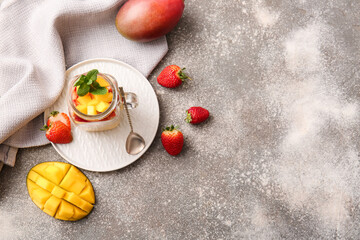 Mason jar with tropical fruit salad on grey background