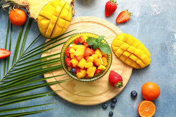 Bowl with mango salad on color background