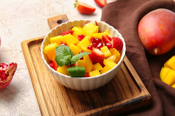 Bowl with mango salad on table