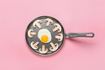 Frying pan with tasty egg and mushrooms on color background