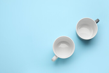 Empty cups on color background